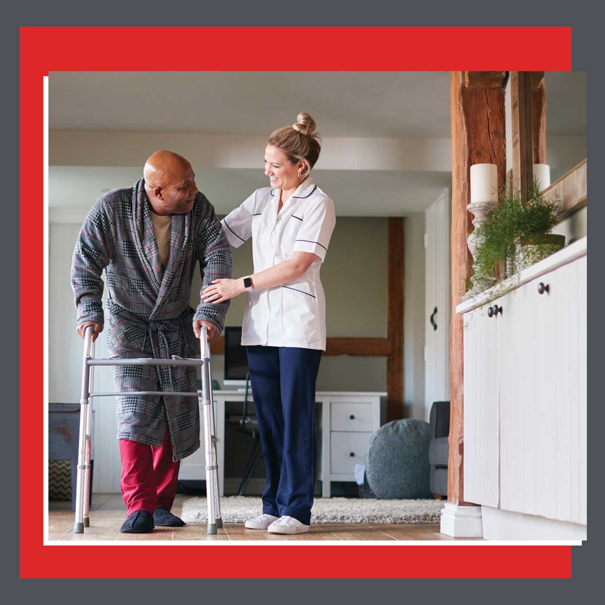 A home nurse in Saline County assisting an older man using a walker inside a warm, home-like setting