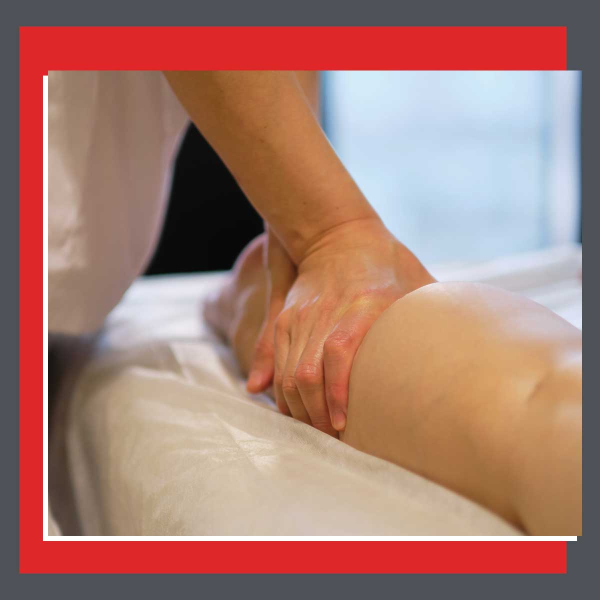 Close-up of a therapist performing manual therapy on a patient's leg during outpatient rehab treatment