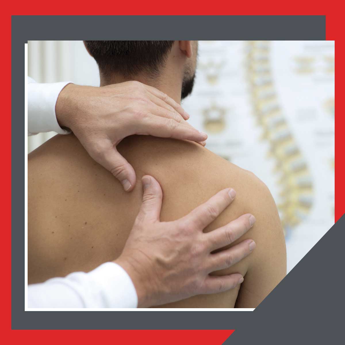 Therapist examining a patient's shoulder during a physical therapy evaluation, with a spine anatomy chart visible in the background