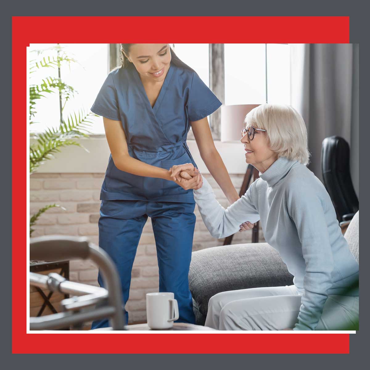 KanCover home care nurse in Saline County, KS assisting an elderly woman from a seated position, highlighting mobility support and compassionate in-home personal aide services.